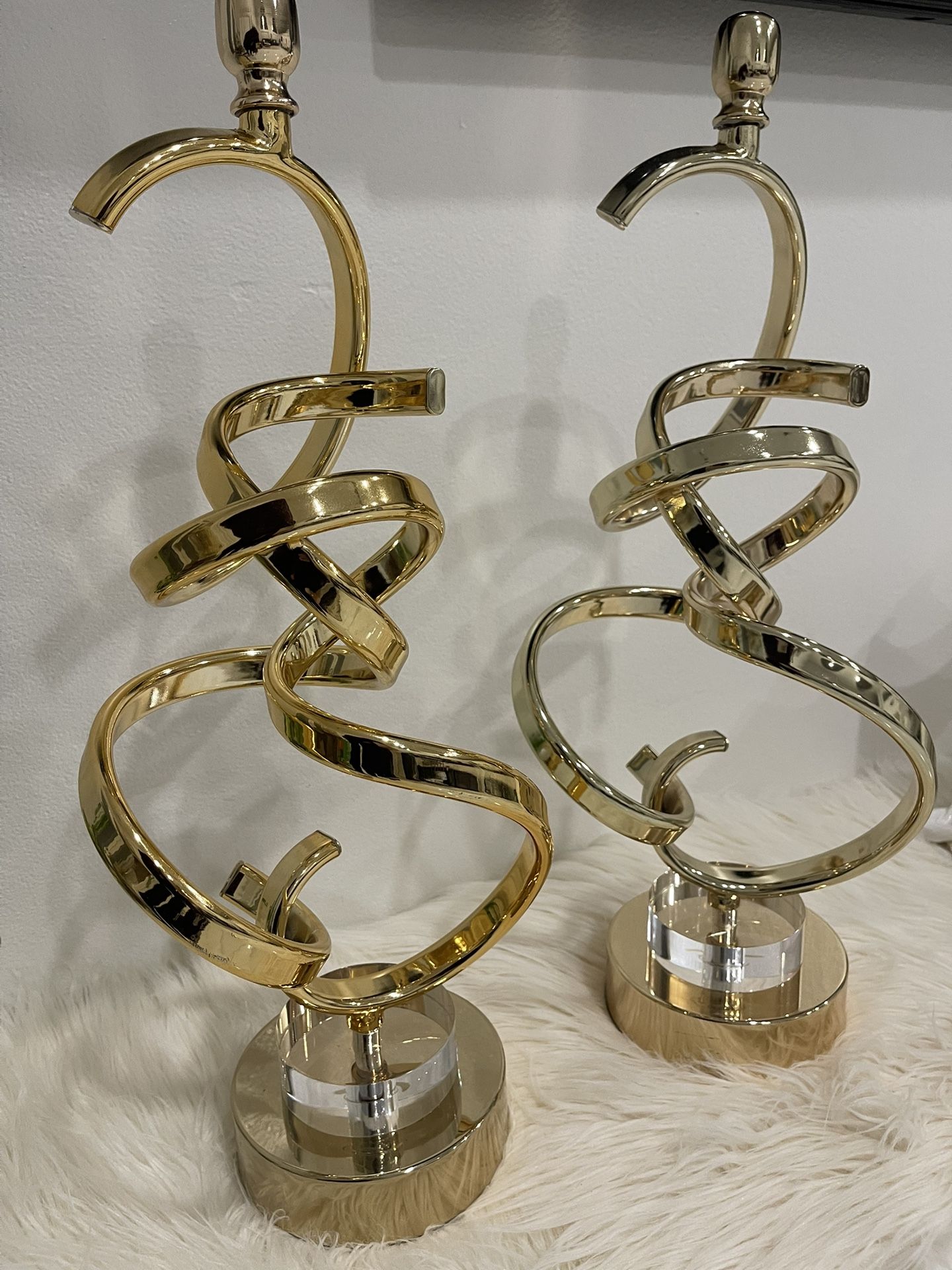 Two gold-finished aluminum modern abstract sculptures with a circular base
