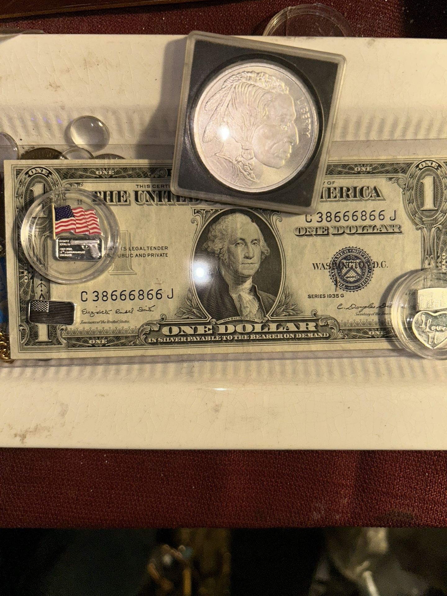 1935 SeriesG with special serial number with 1 ounce Indian buffalo silver ground and five individual small grams colorized American flag. Theey write