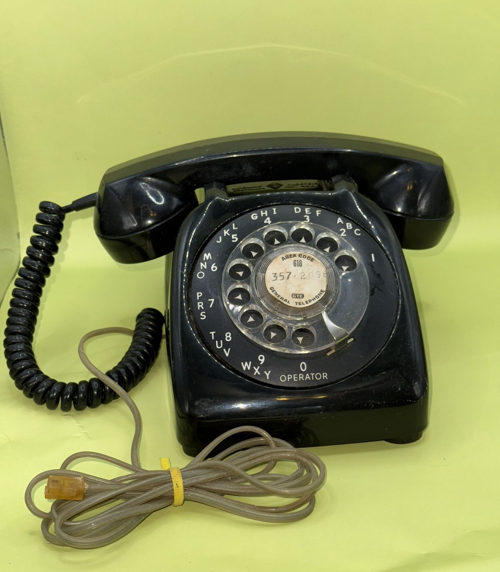 vintage 1970s automatic electric phone with a black rotary dial,