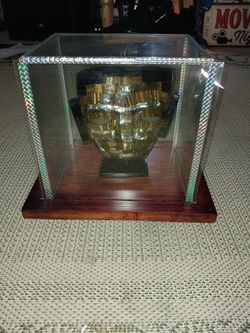 Stone mask on wood stand in glass case made in mexico
