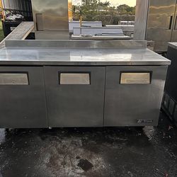 True 72 3/8" refrigerator with countertop and 3 9/16" splash guard