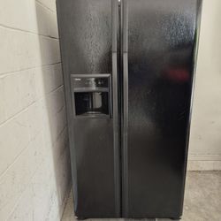 Black Kenmore Side-by-Side Refrigerator with Multiple Shelves and Door Compartments.