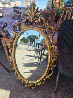 vintage oval wall mirror with a gold frame