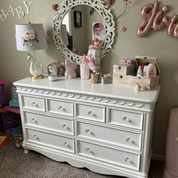 baby room set crib and a dresser with TV table lamp mirror and toy boxes with also some extra toys 