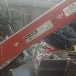 hydraulic engine hoist, often called a "cherry picker," used for lifting and moving heavy automotive components like engines.